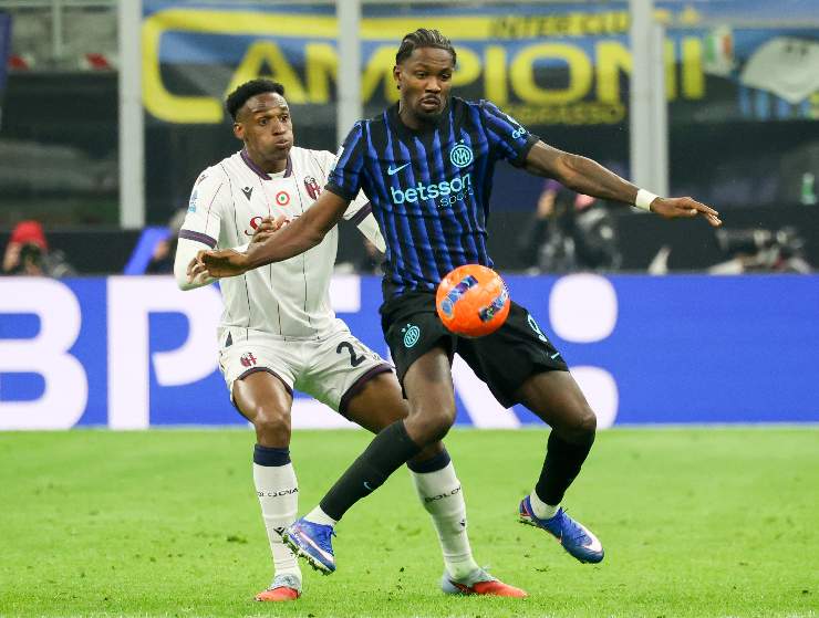 Il centrale del Bologna che cerca di contrastare Thuram dell'Inter